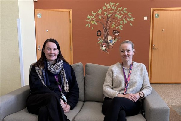 Elina Warnicki ja Riitta Kujansivu istuvat sohvalla ja katsovat kameraa.