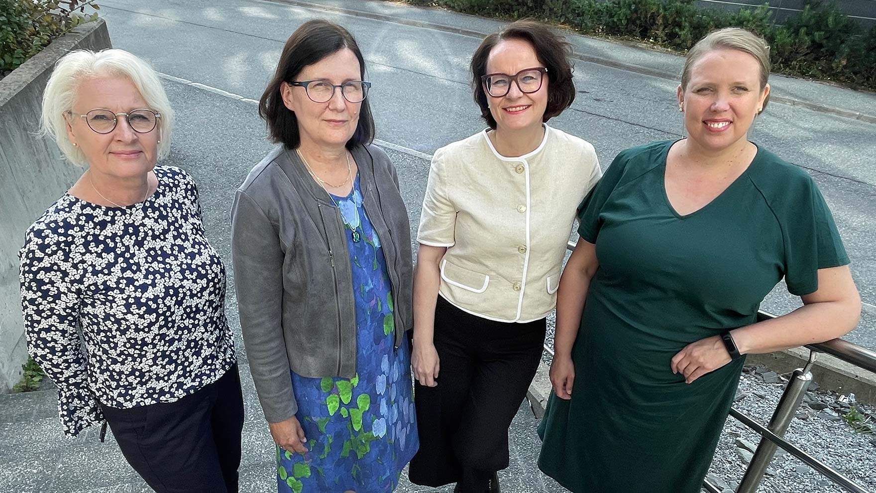 Neljä julkaisun kirjoittajaa poseeraa ryhmäkuvassa.