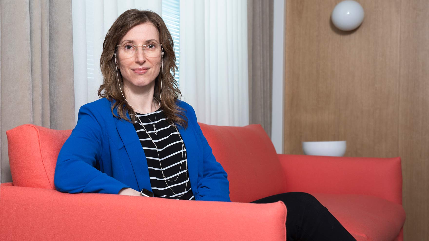 Kati Kristiansson istuu sohvalla.