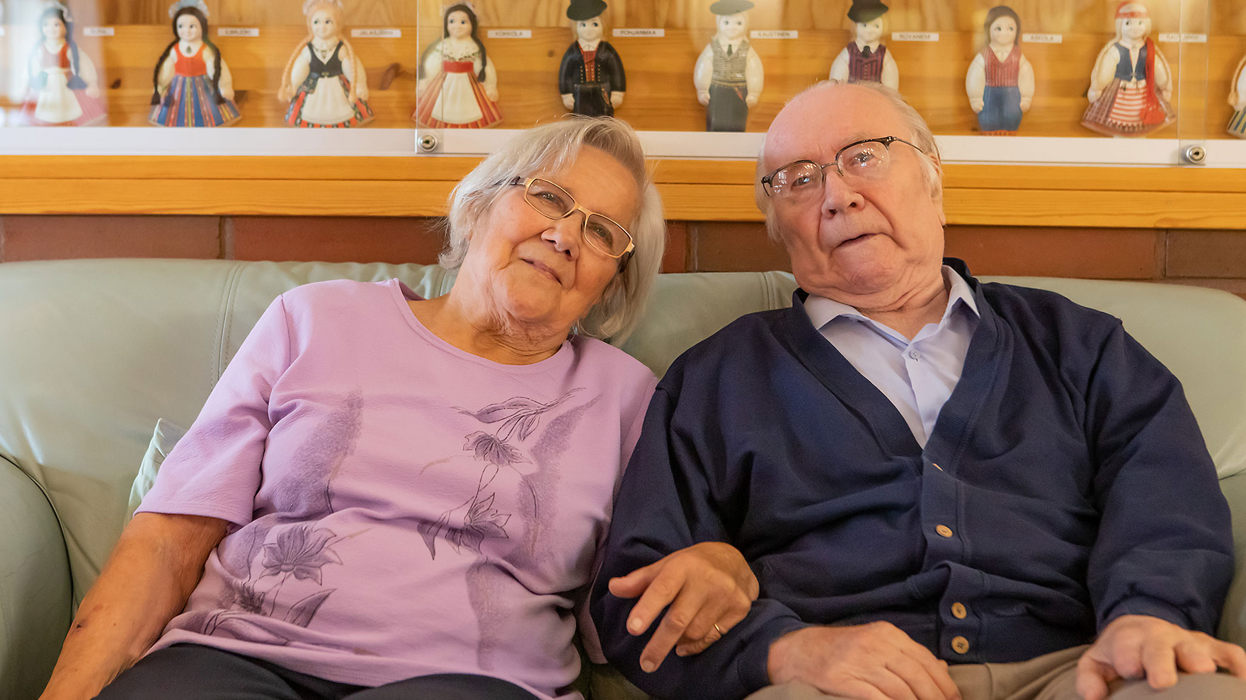 Woman and man sitting side by side on a sofa.