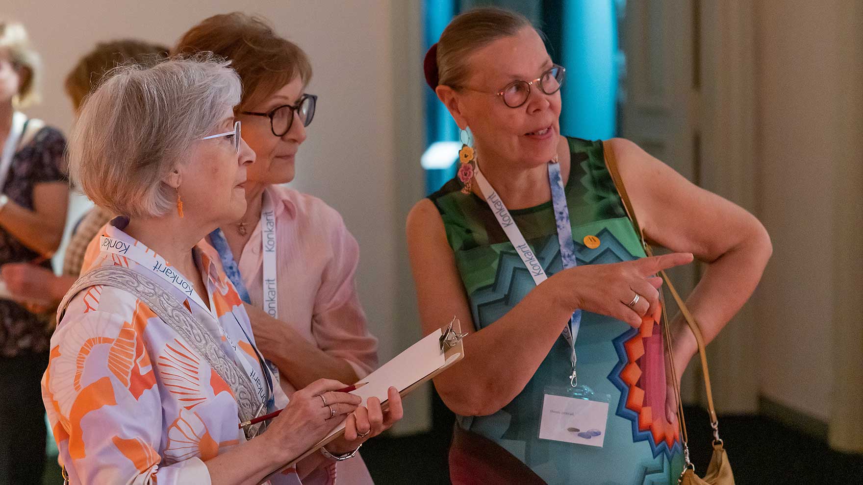 Kolme naista museossa vierekkäin katsomassa keskittyneesti samaan suuntaan.