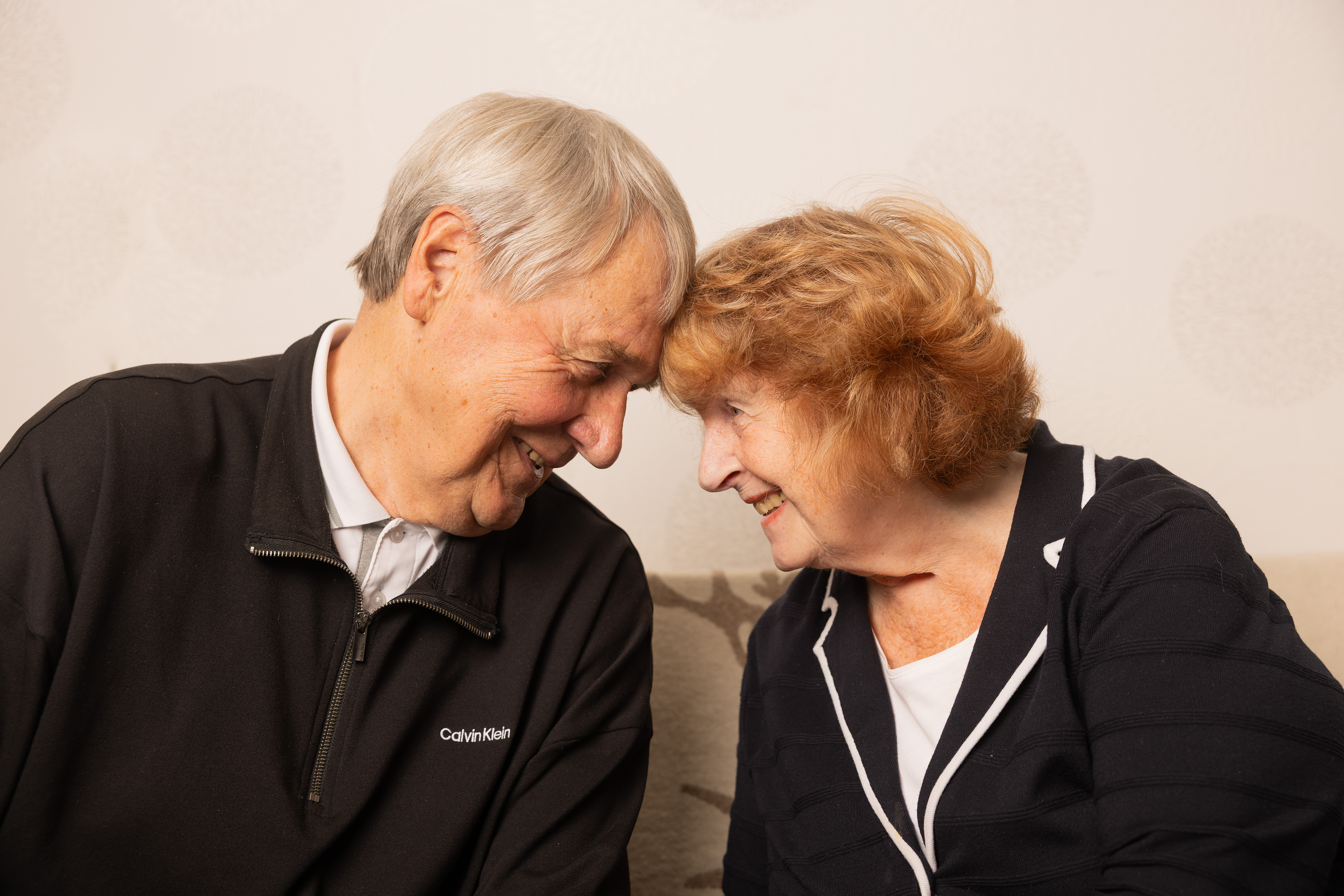 Kaksi ikäihmistä otsat toisiaan vasten.