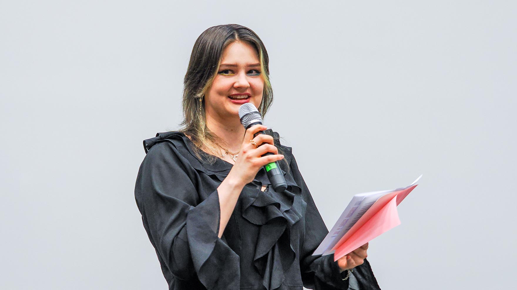 Nuori nainen puhuu mikrofoniin.