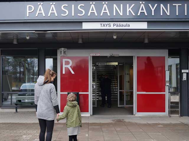 Tyttö ja hänen äitinsä Tays sairaalan pääsisäänkäynnin edessä.