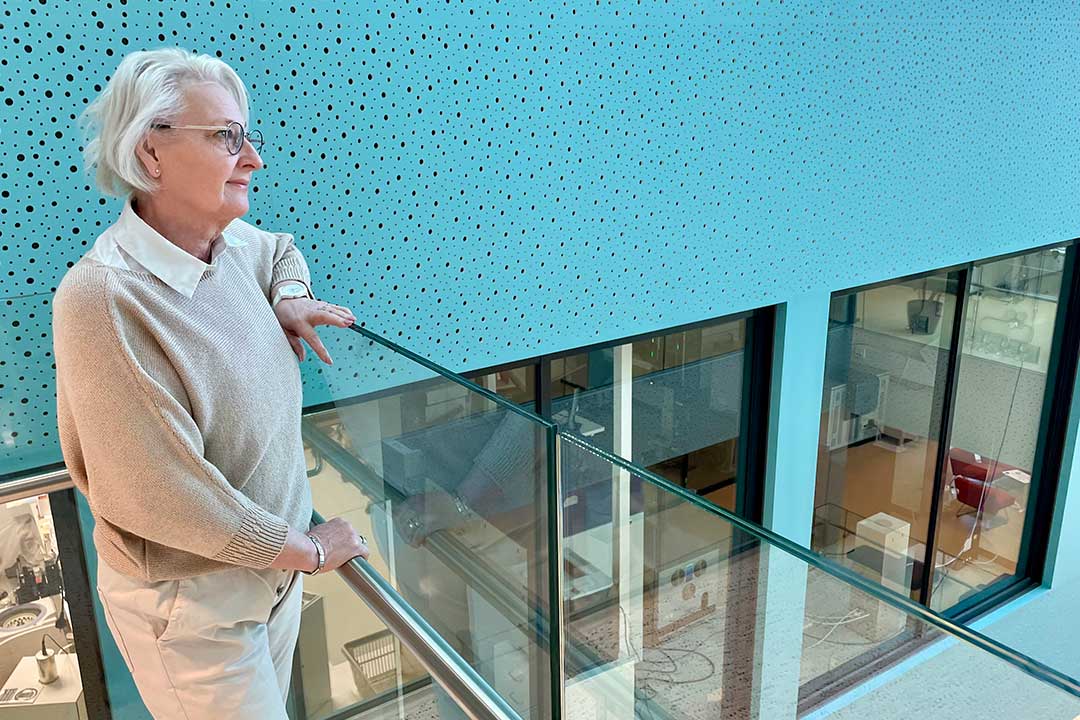 Nainen seisoo portaikossa ja katsoo poispäin.