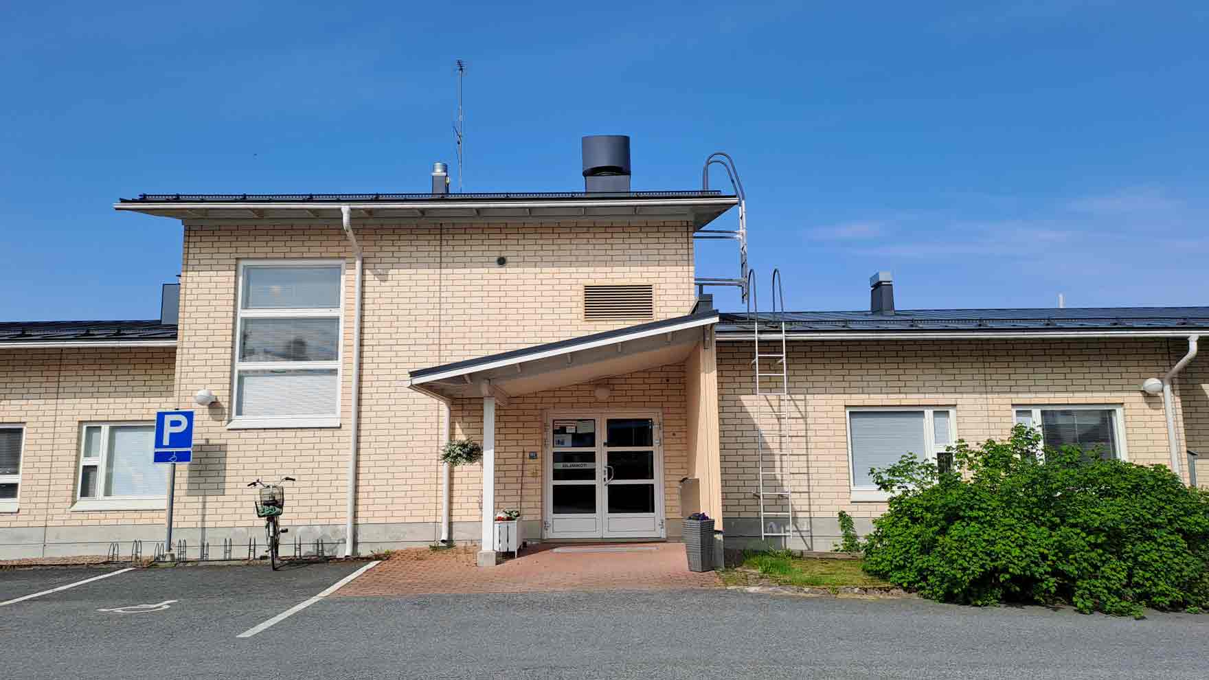 Vaaleatiilisen rakennuksen sisäänkäynti