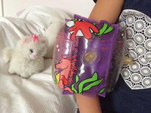 Lapsen käsivarsi, jossa uimakelluke.