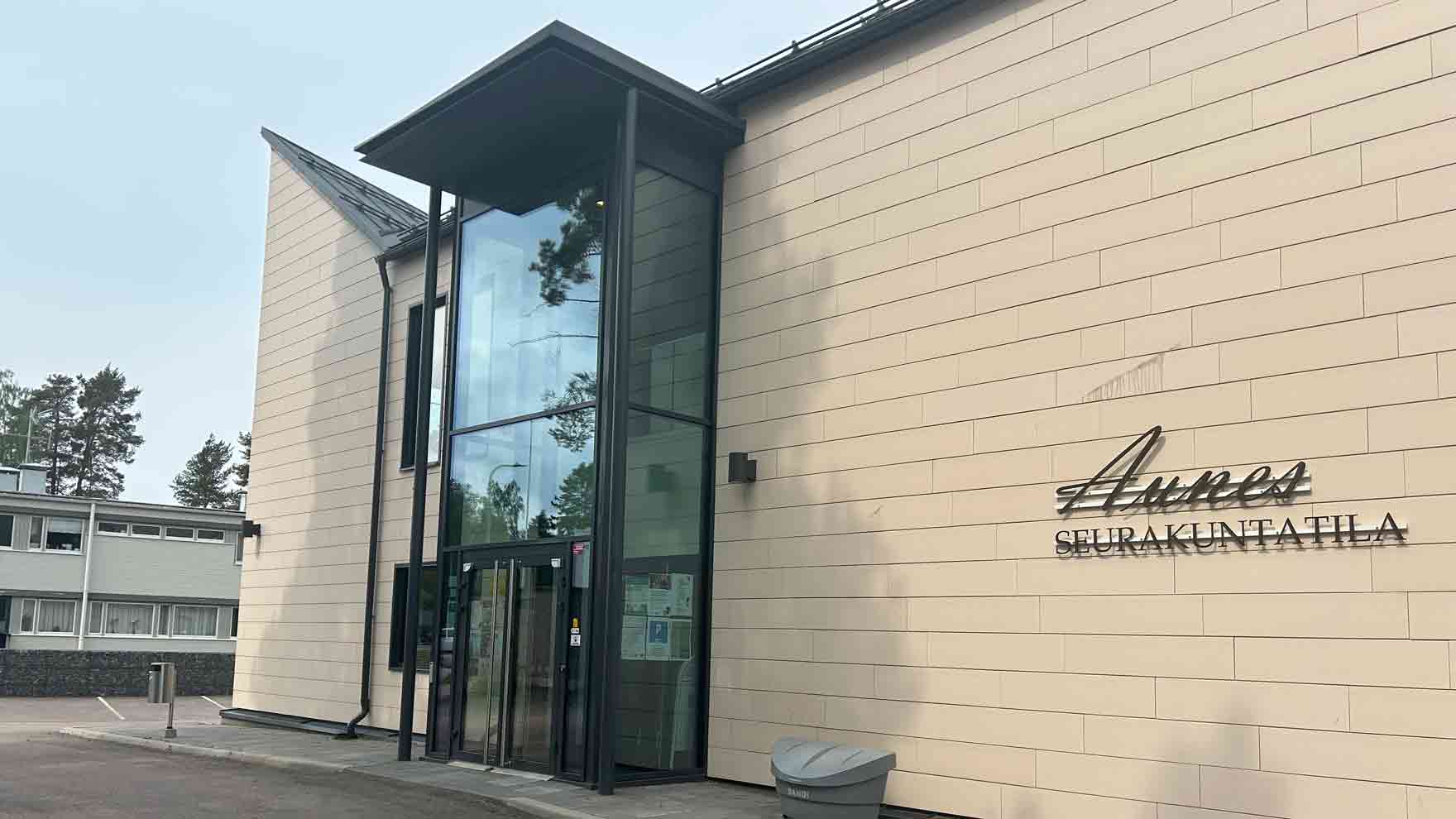 Korkeahko vaalea rakennus, jonka seinässä lukee Aunes seurakuntatila.