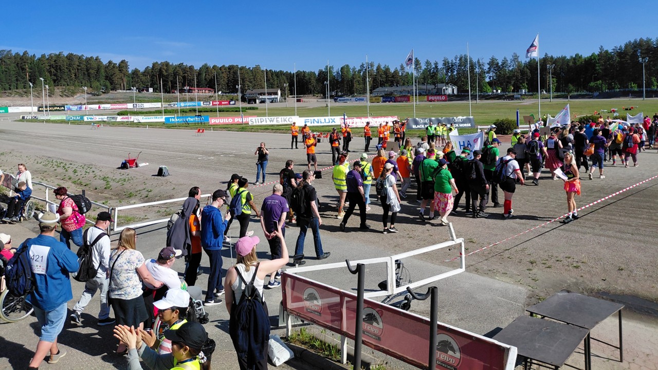 Ihmisiä kävelee Teivon kentällä.