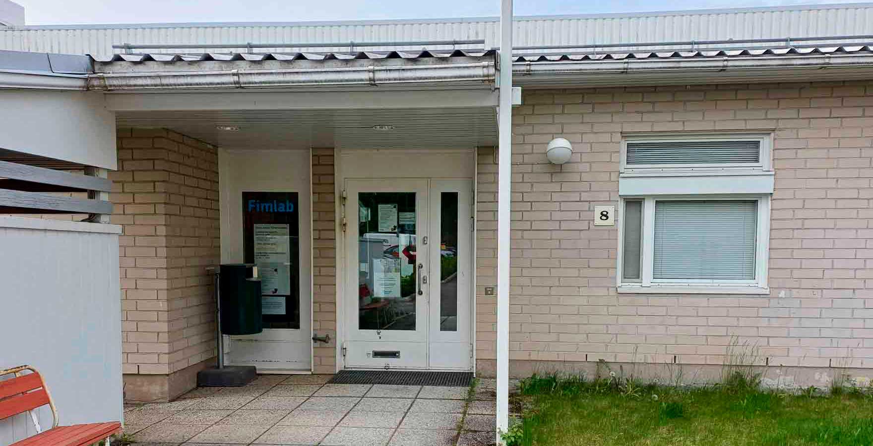 Sisäänkäynti vaaleatiilisessä rakennuksessa.