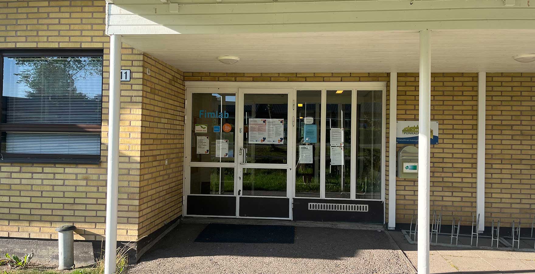 Keltatiilisen rakennuksen sisäänkäynti.