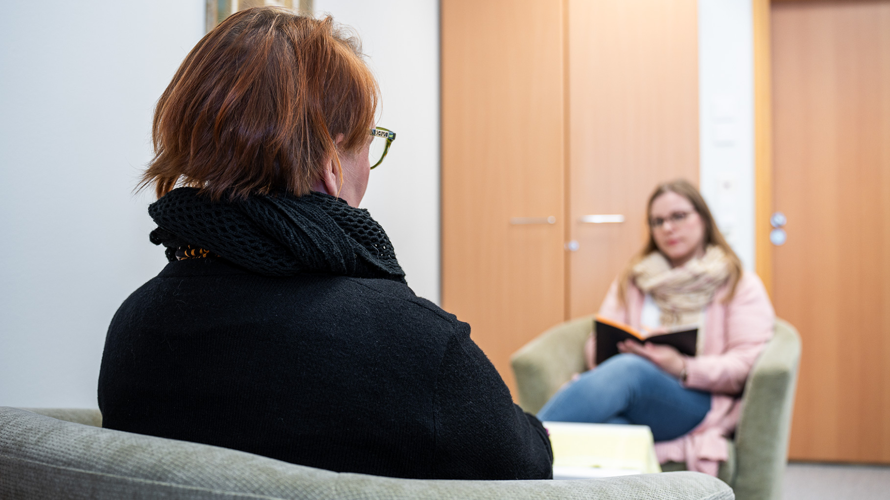 Asiakas ja ammattilainen juttelevat miepä-tiimin vastaanotolla.