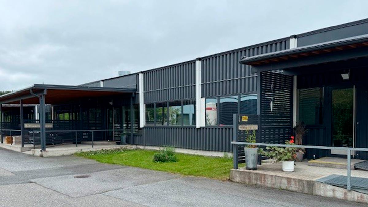 Tummasävyinen tasakattoinen rakennus, jossa on kaksi sisäänkäyntiä.