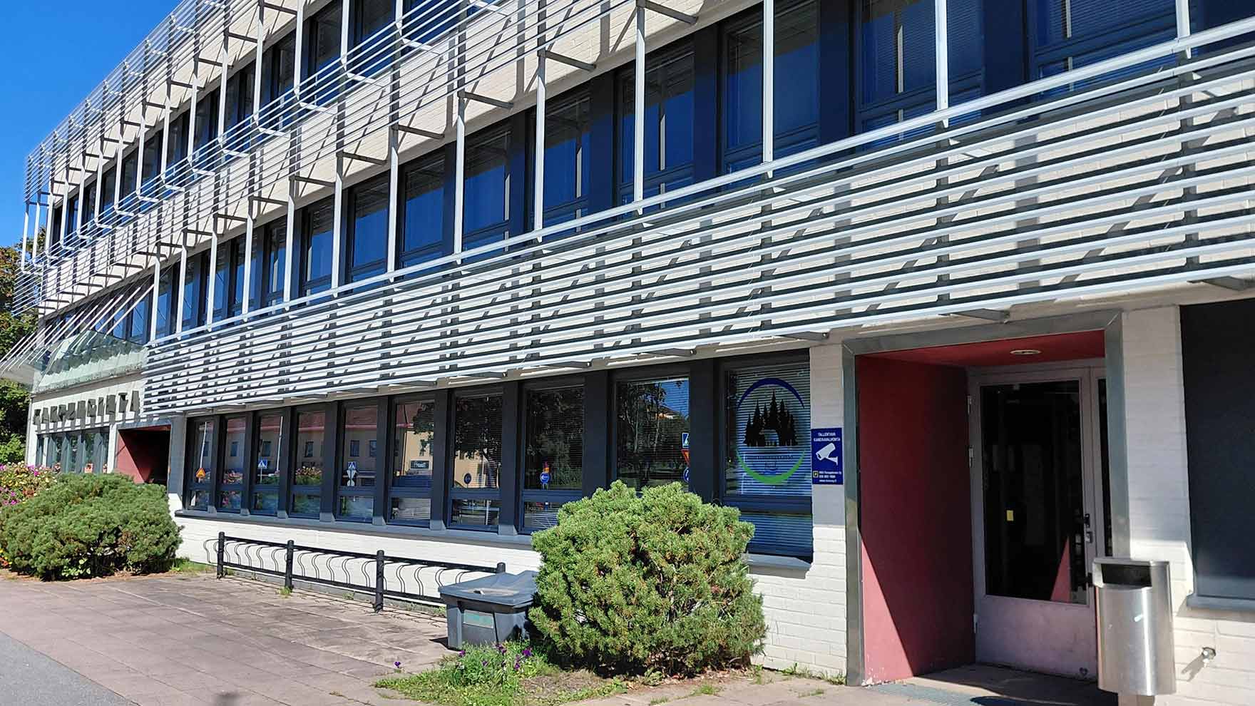 Kolmikerroksisen talon julkisivu, jonka kerrosten välissä metallikehikkoa.