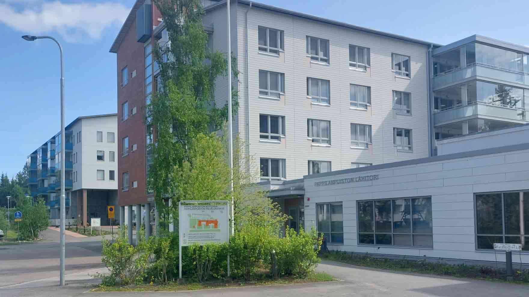 Korkea rakennus ja matalampi siipi, jossa lukee Pappilanpuiston lähitori.