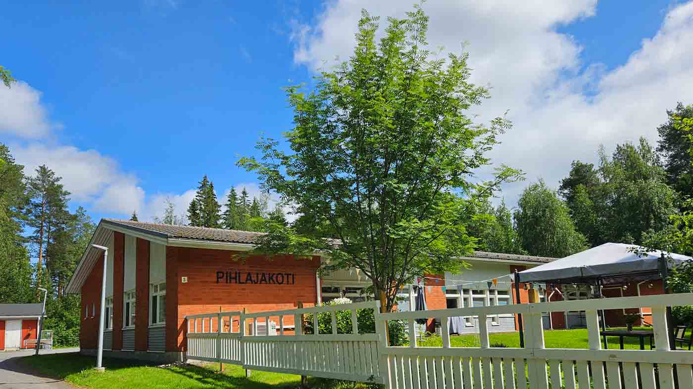 Punatiilinen rakennus, jonka pihassa iso pihlaja