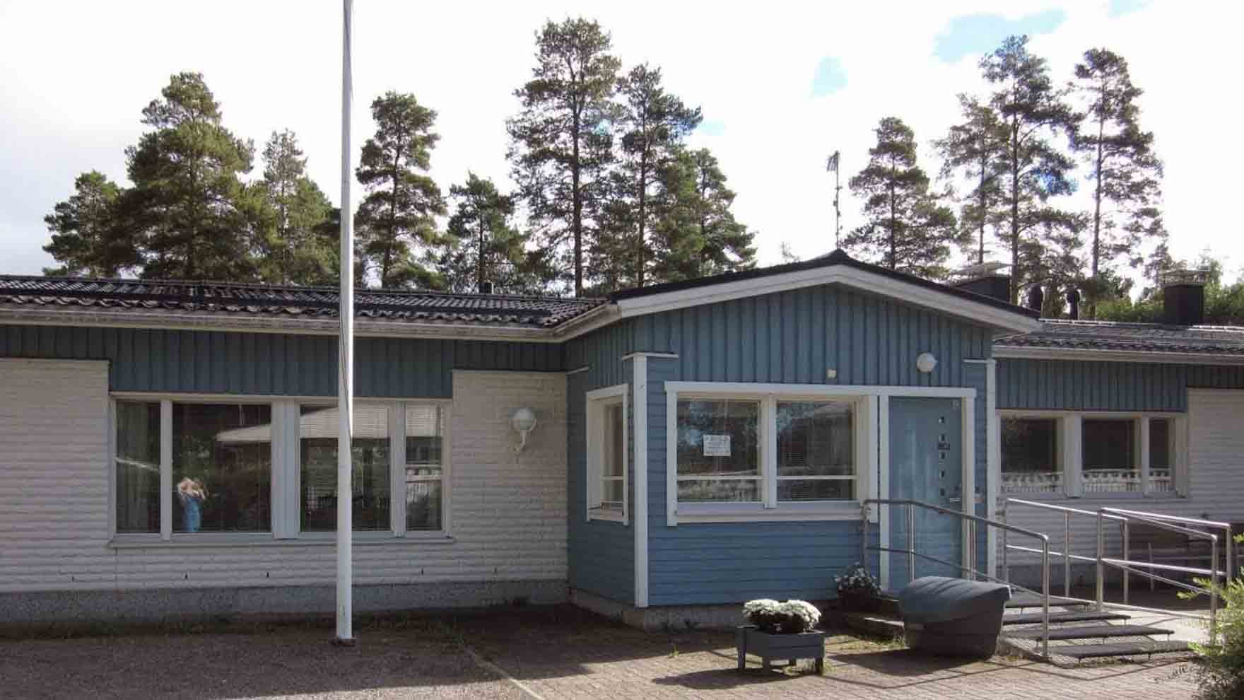 Matalan rakennuksen sisäänkäynti. Rakennuksessa on valkoista ja sinistä.