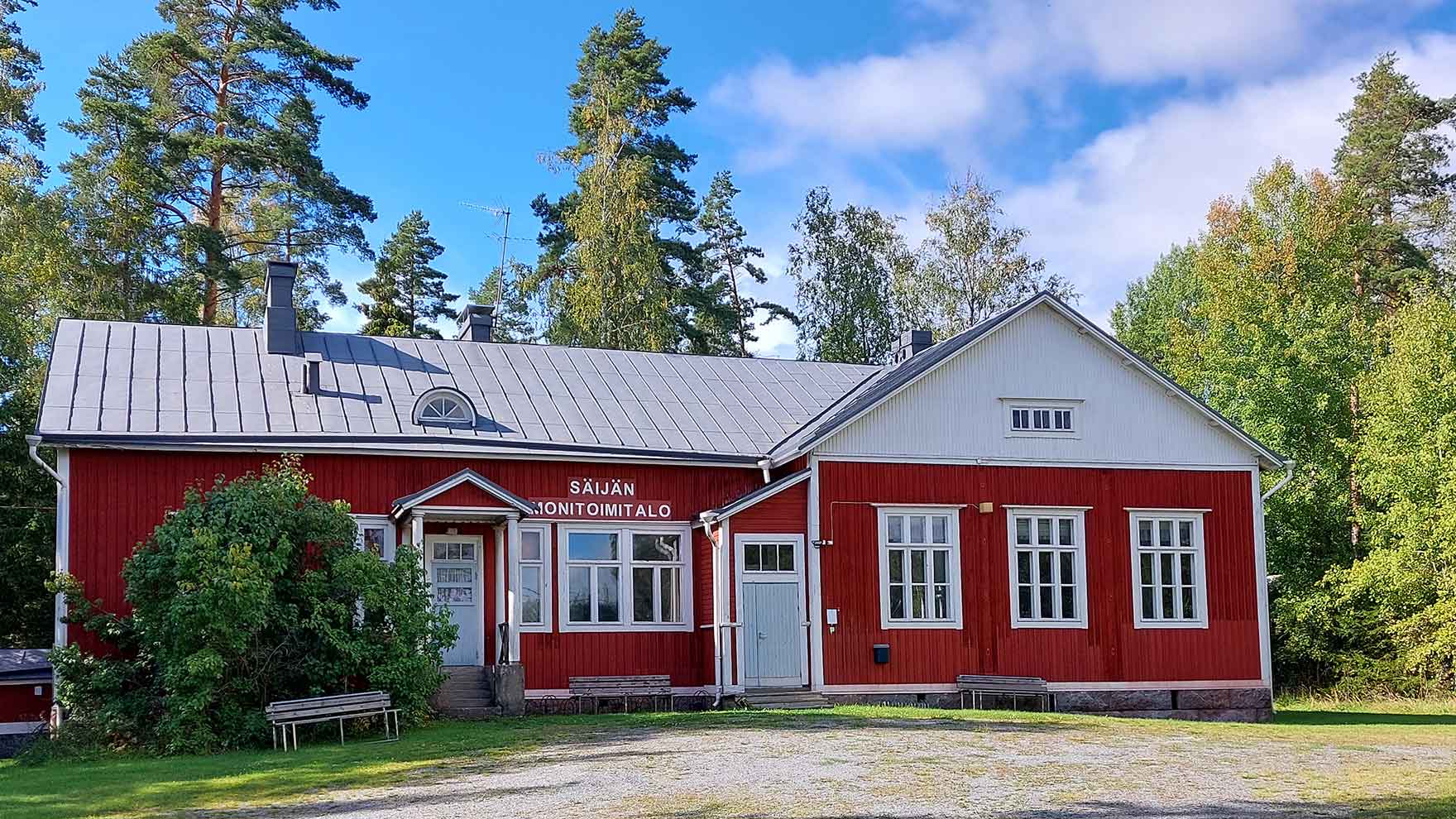 Punainen puurakennus, jonka sisäänkäynnin yläpuolella lukee Säijän monitoimitalo.