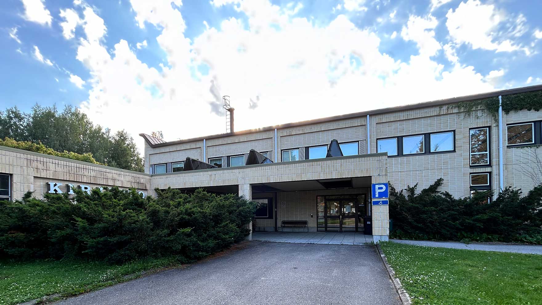 Harmaan betonisen kirjaston sisäänkäynti.