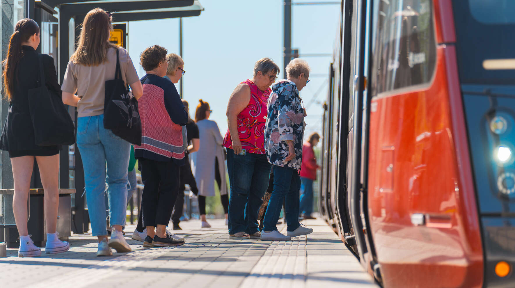 Ihmisiä nousemassa Tampereen ratikan kyytiin.