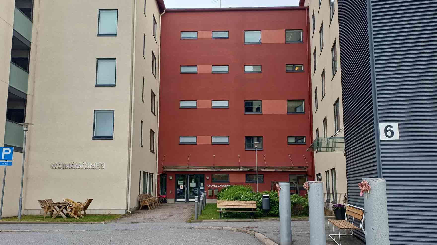 Korkean puna- ja vaaleasävyisen rakennuksen sisäänkäynti