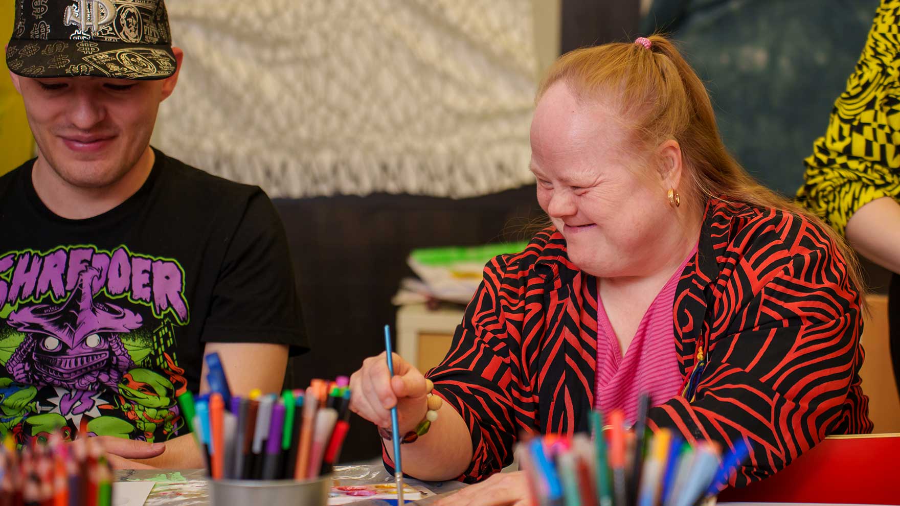 Nuori mies ja nainen maalaavat vesiväreillä.