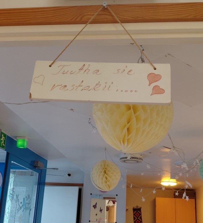 Venlantuvan ovenkarmista roikkuu kyltti, jossa lukee "Tuutha sie vastakii...".