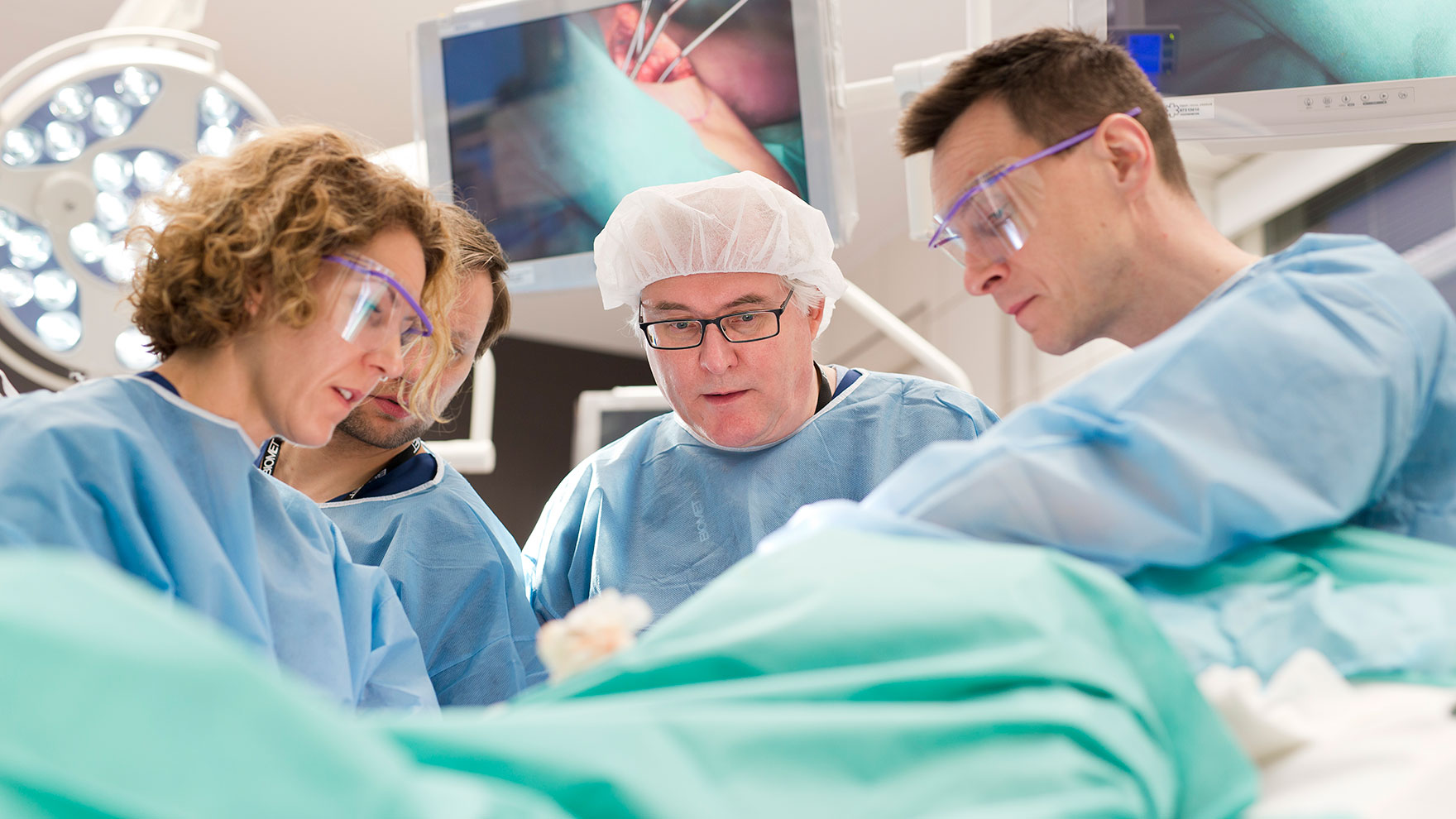 Kirurgit leikkaussalissa työn ääressä.