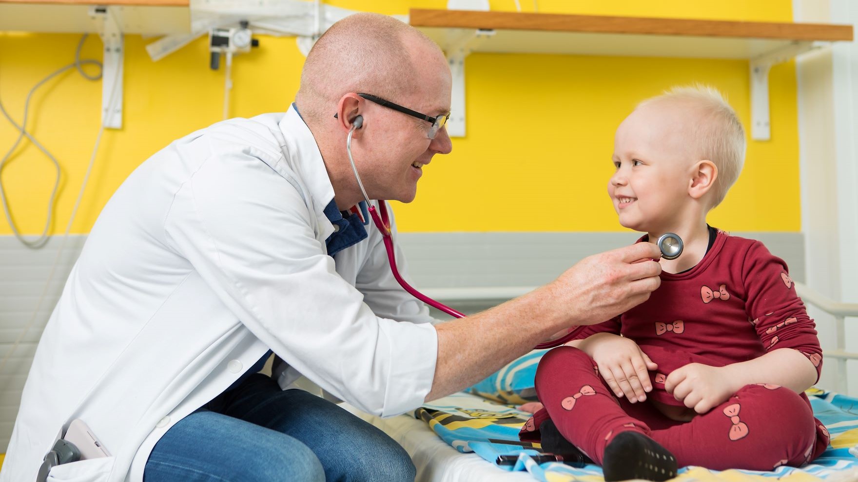 Lääkäri kuuntelee stetoskopilla lapsen rintaa.